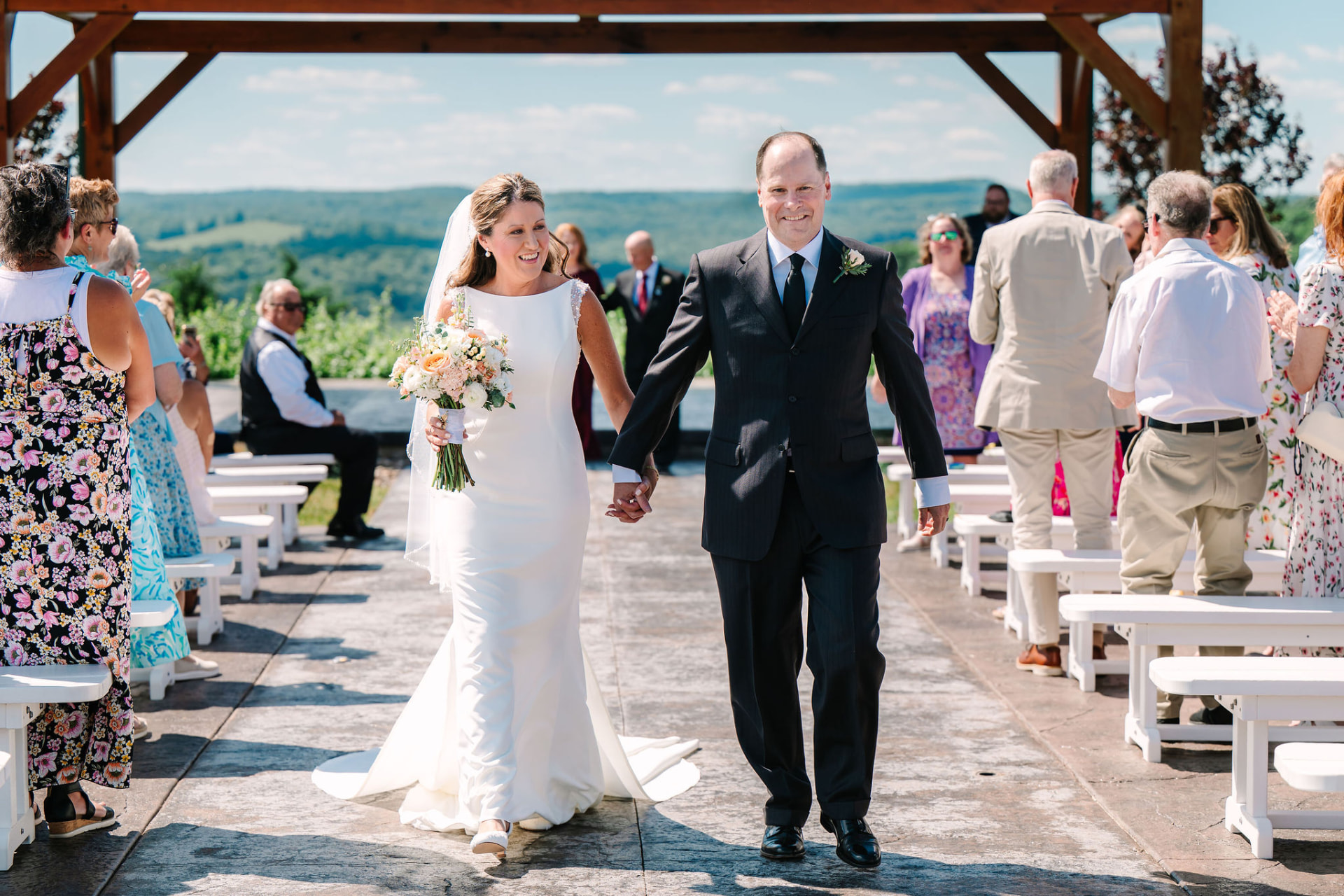 Greg and Sonnie walking back up the aisle as guests applaud