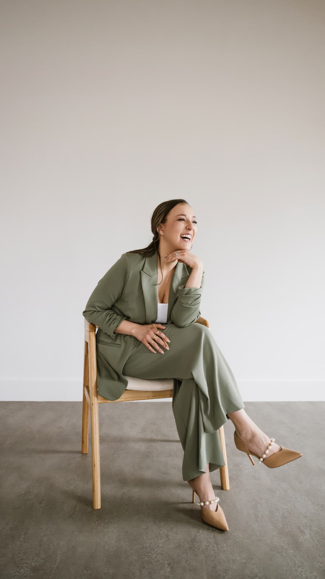 Tara Minniear, owner of Sparkling Pines Event Co., smiling in a sage suit