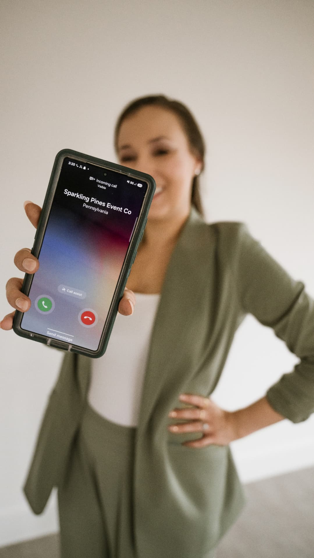 Tara holding up a phone showing an incoming call from Sparkling Pines Event Co.