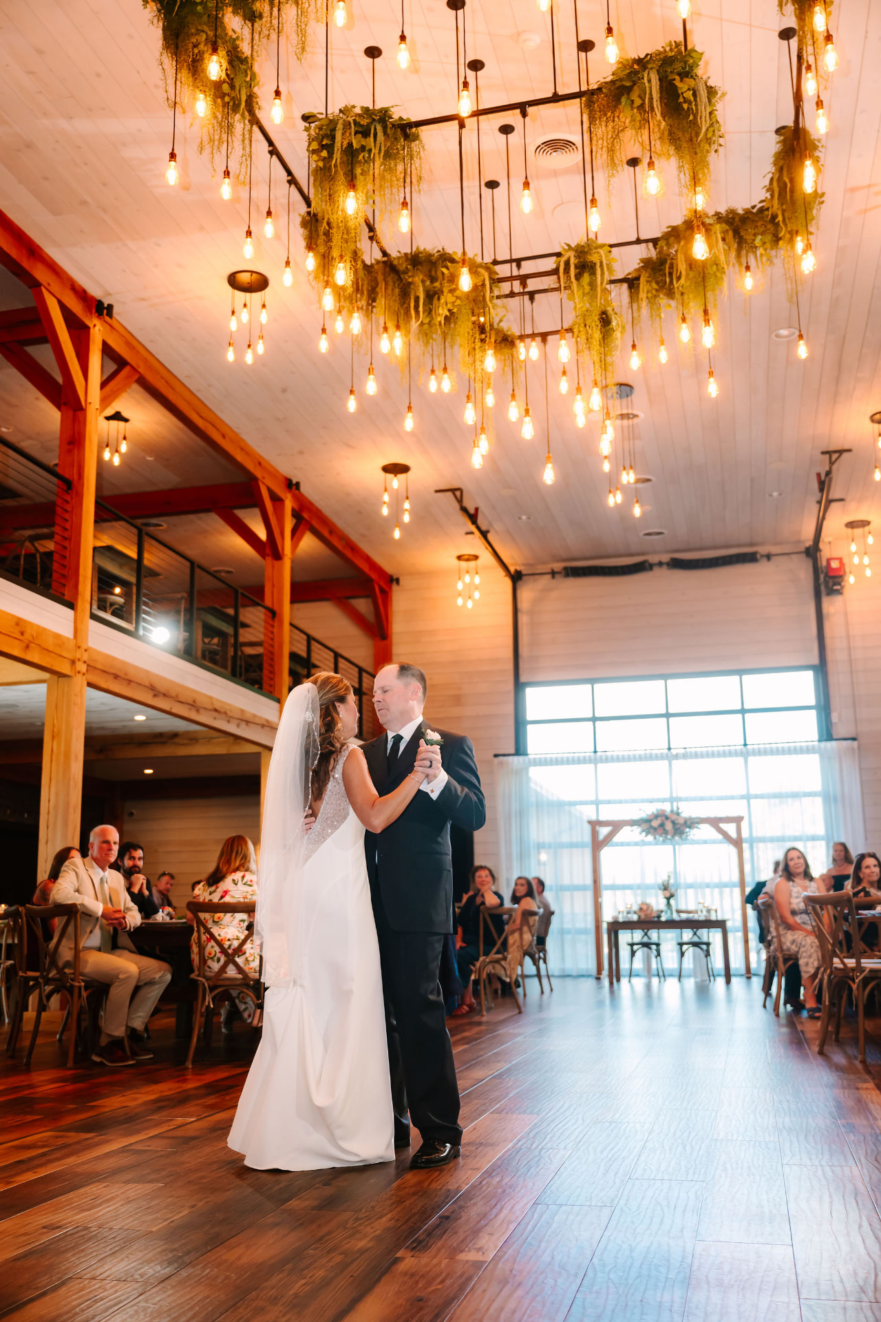 Greg and Sonnie's first dance beneath a canopy of Edison bulbs and greenery