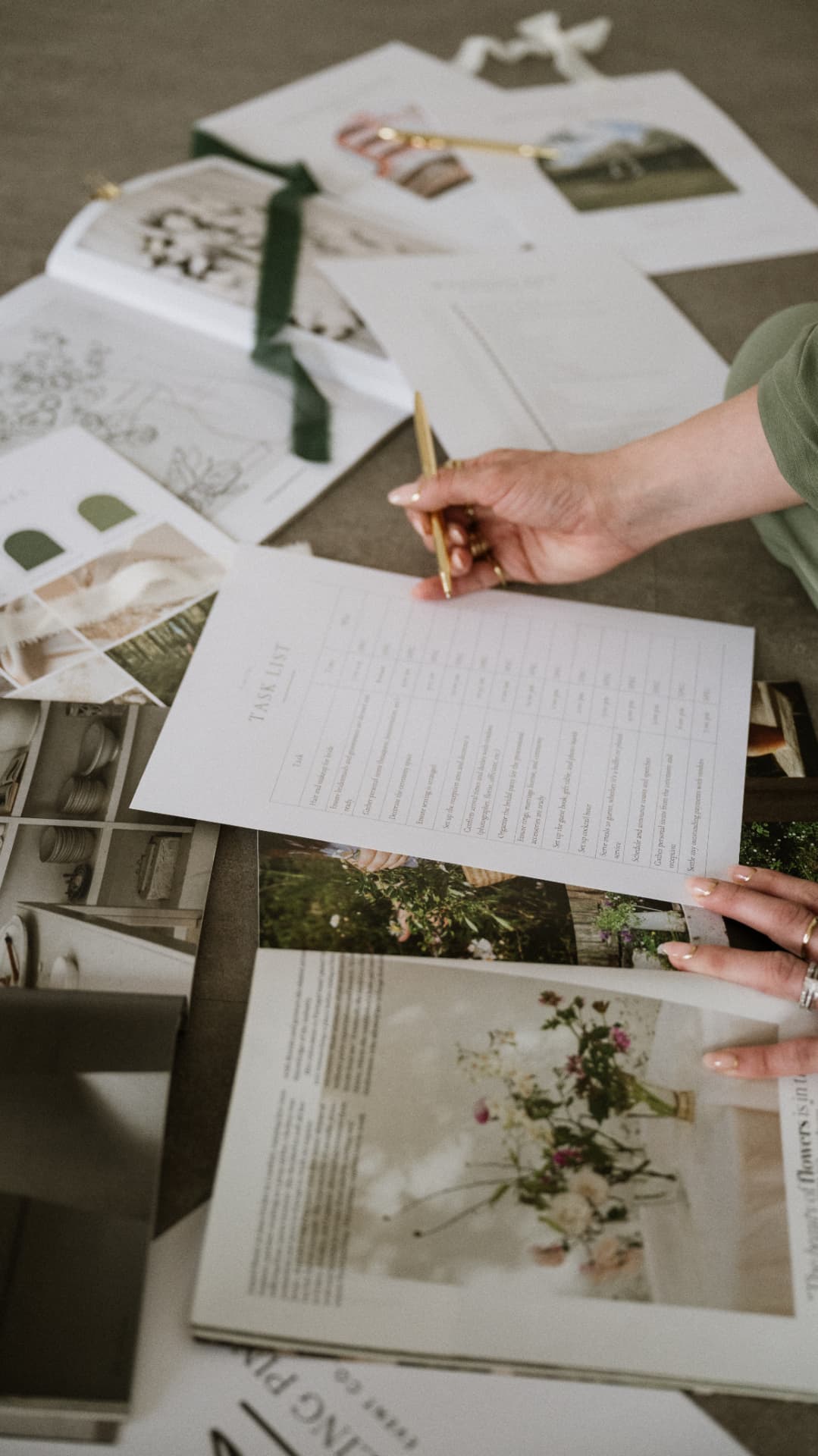 Tara's hand writing on a wedding task list among mood boards