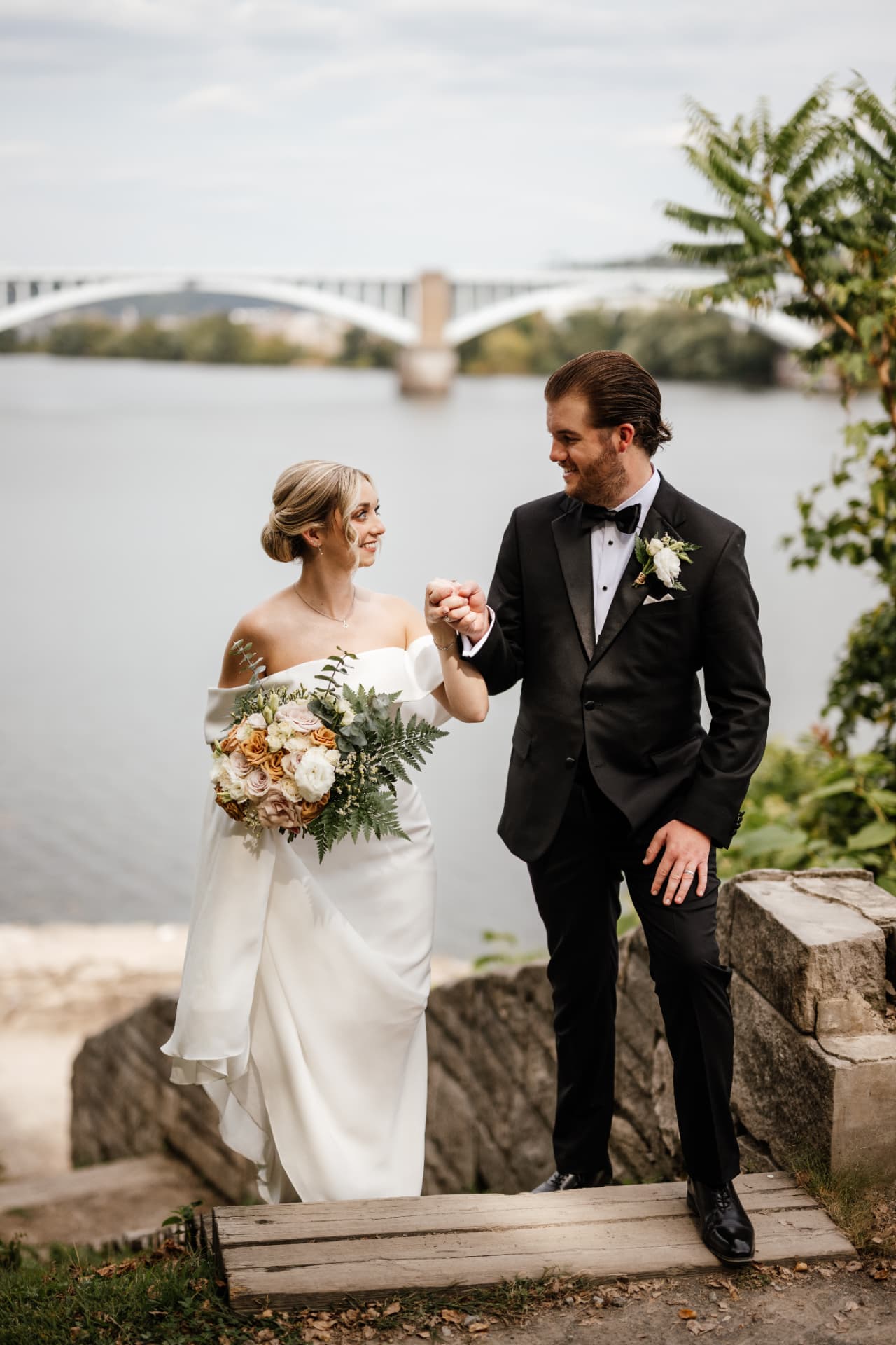 Sydney and Duncan together by the river and bridge at golden hour