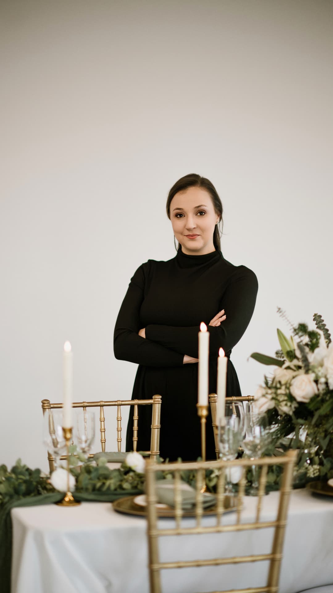Tara standing behind a candlelit table with her arms crossed