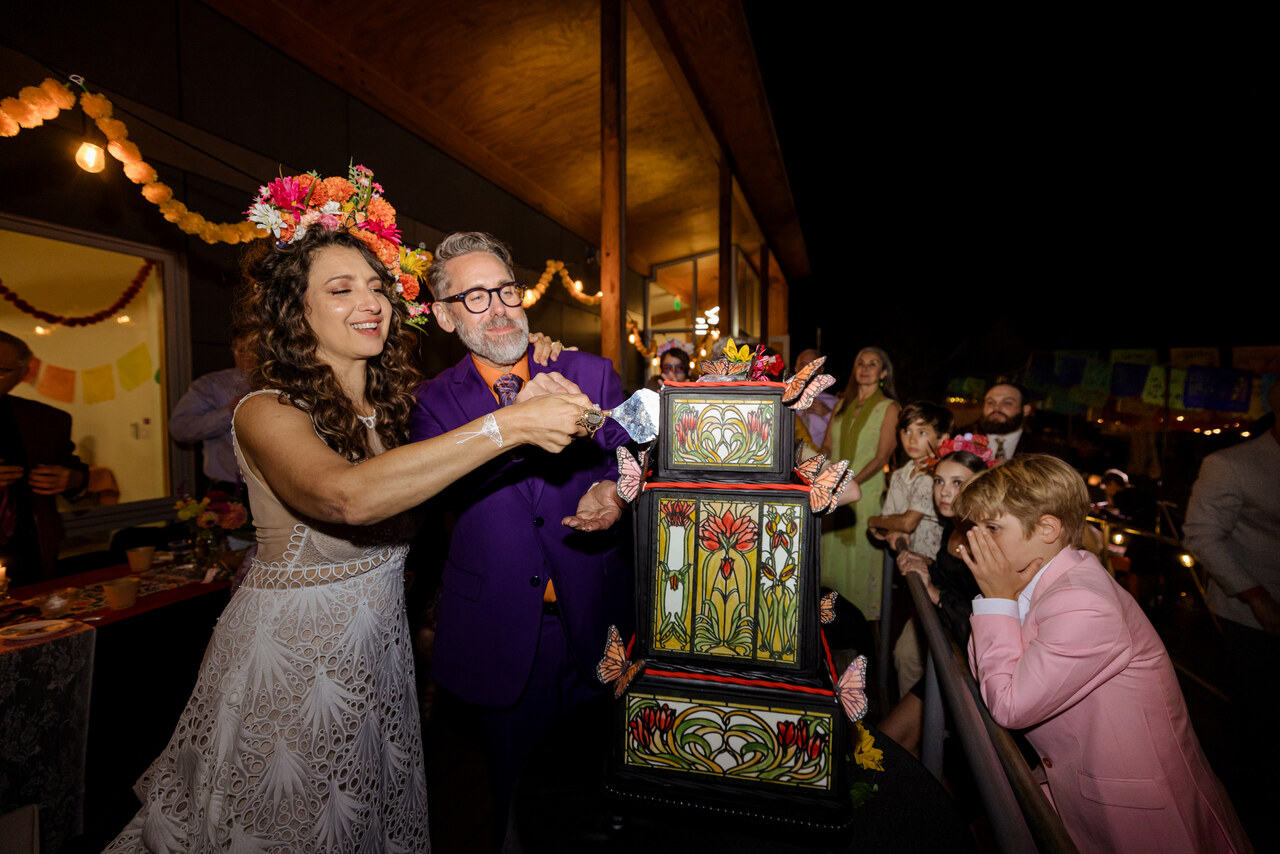 Benjamin and Alison cutting a stained glass style cake at night