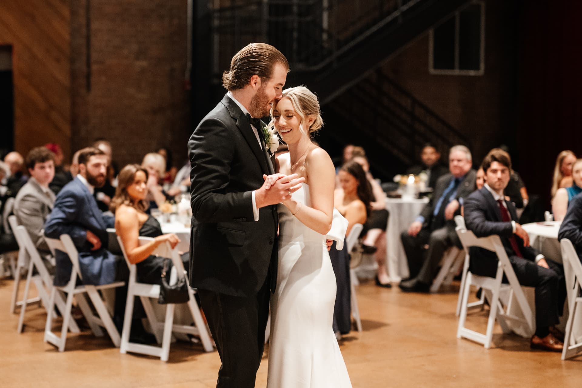 A close view of Sydney and Duncan dancing under the string lights