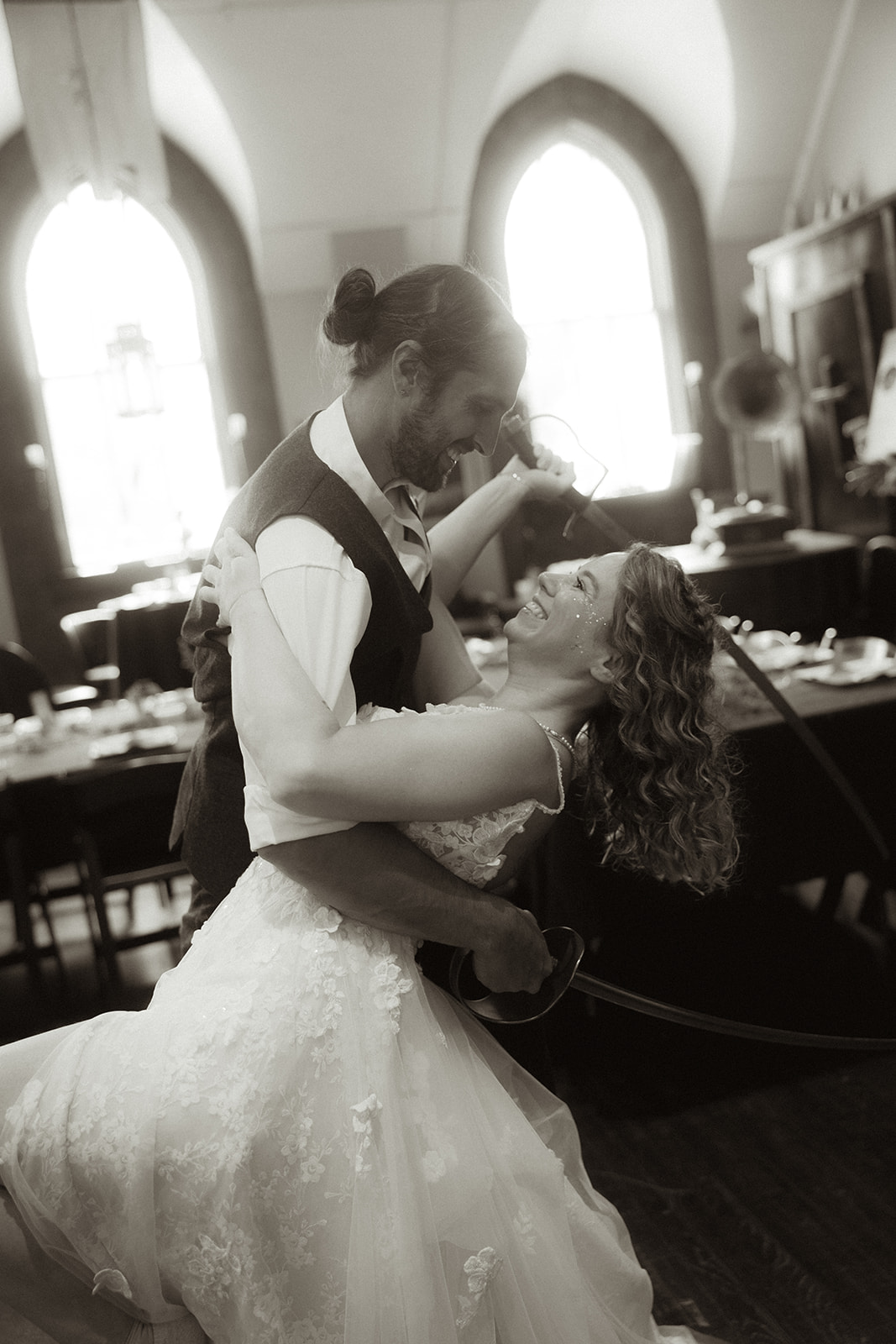 Matt dipping Dani during a dance in front of tall arched windows