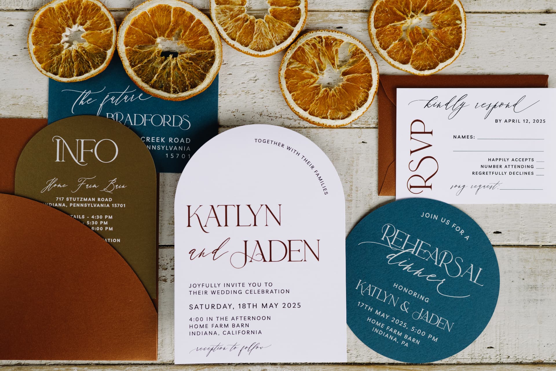 A colorful invitation suite laid out with dried orange slices